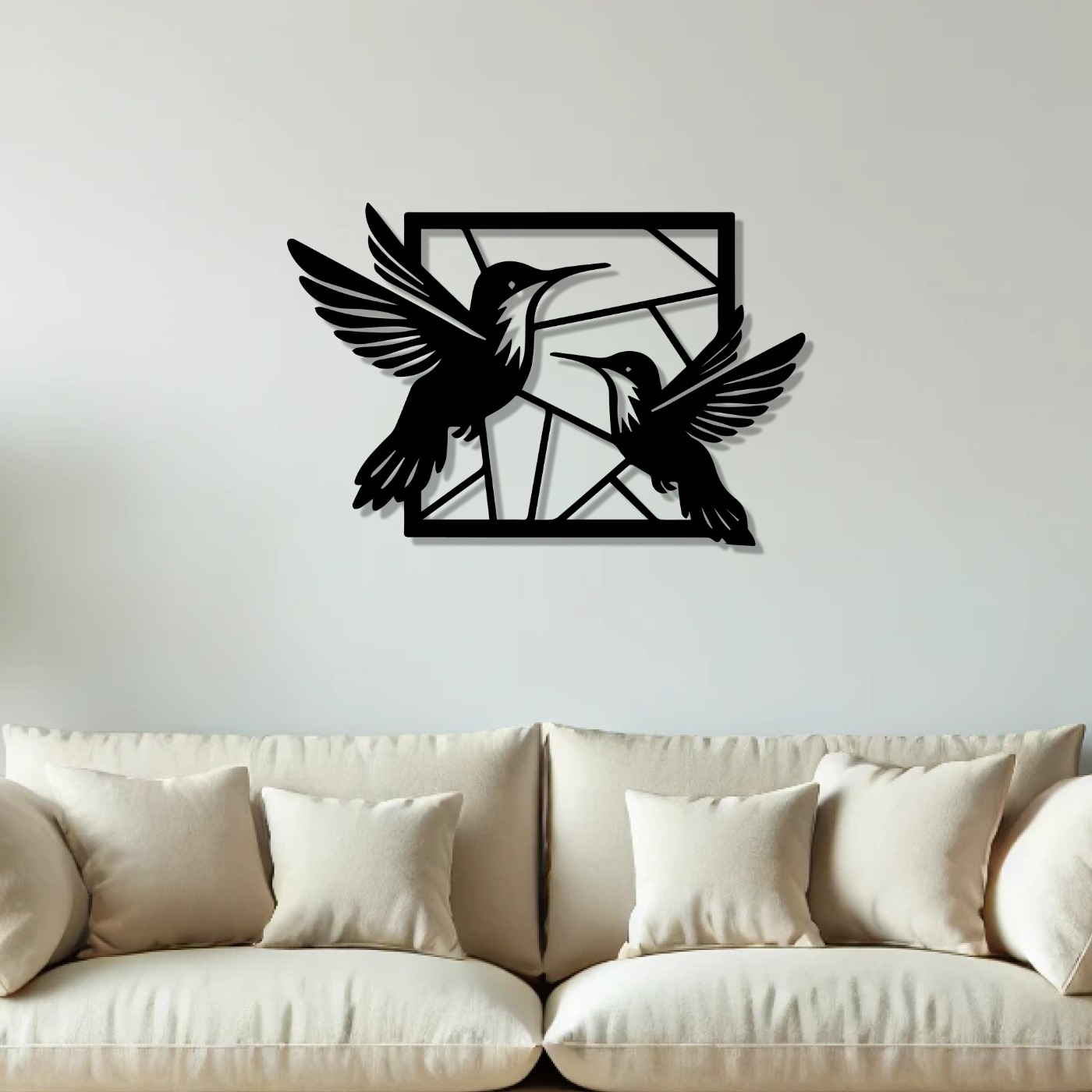 Birds wall art: flying hummingbird metal silhouettes mounted above a cream sofa in a modern living room