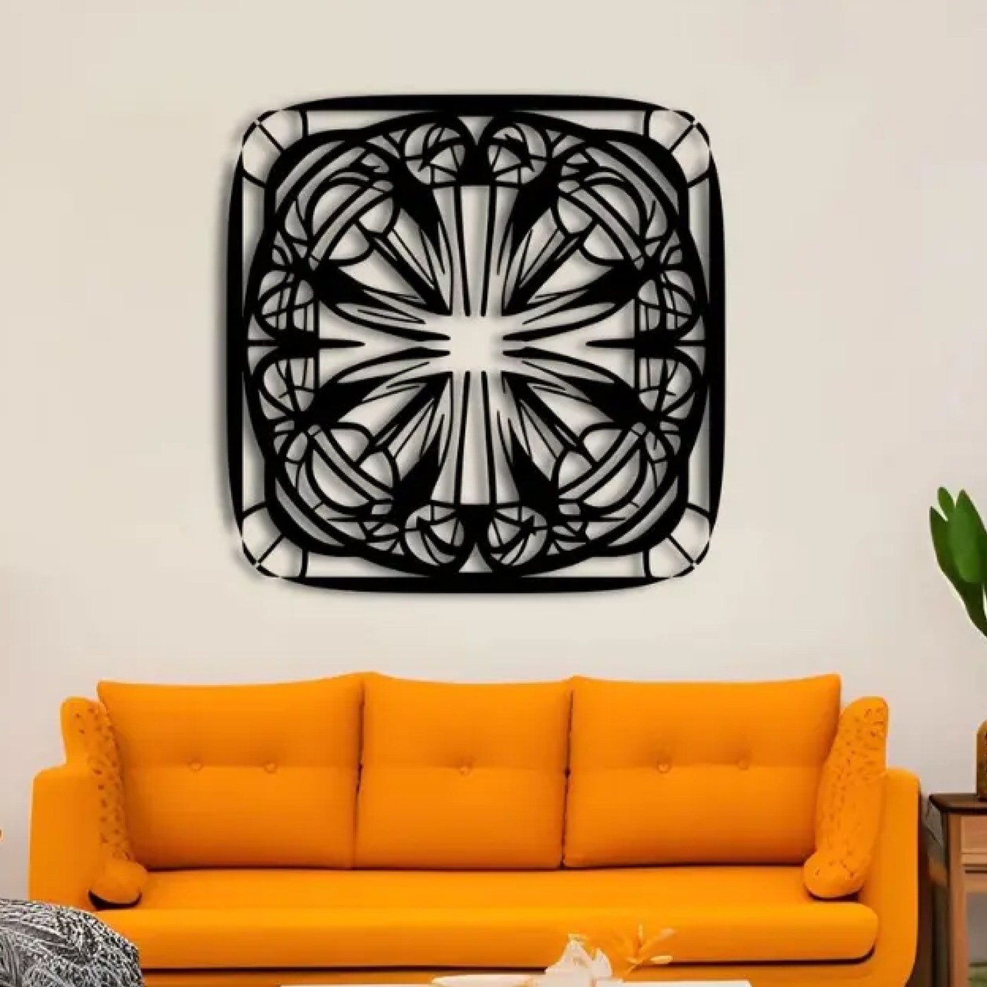 Metal wall art for living room: Symmetrical Mandala laser-cut black steel wall art mounted above an orange sofa