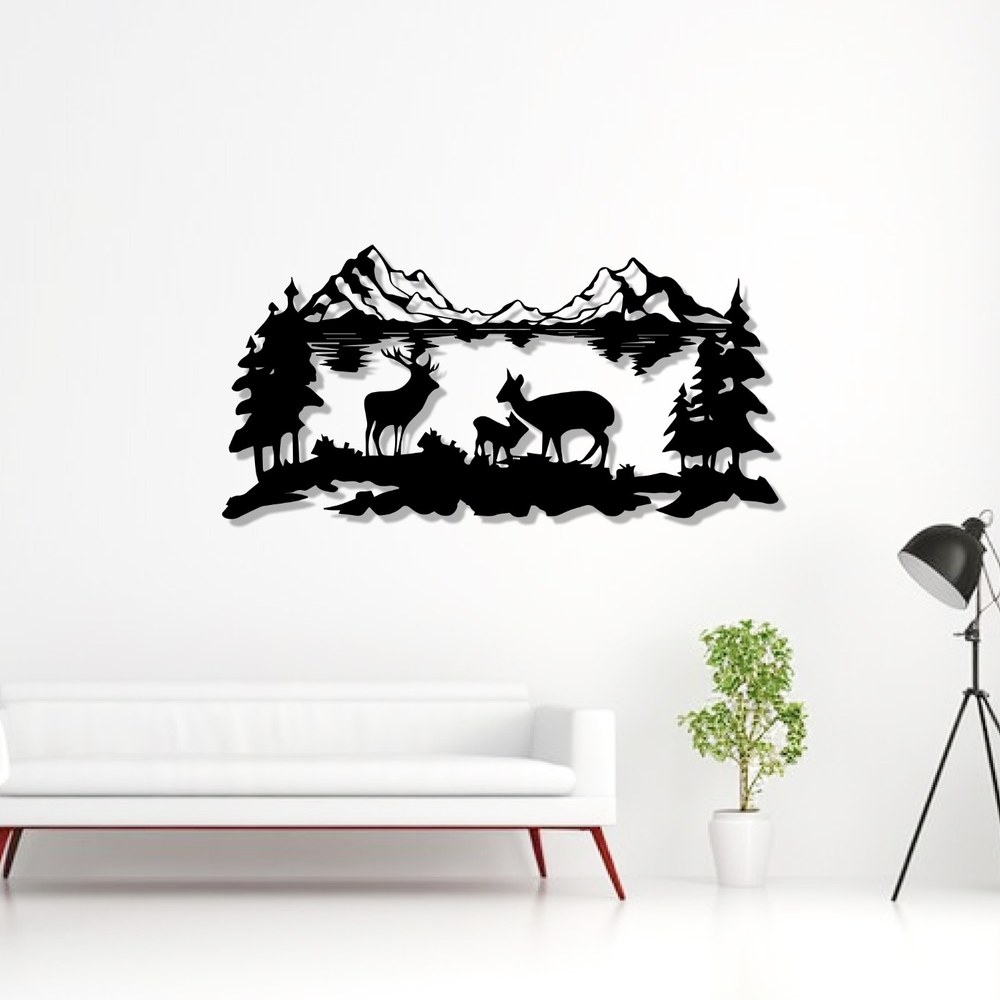 Deer wall art: black laser-cut metal deer family with mountains, pine trees and a lake above a white sofa