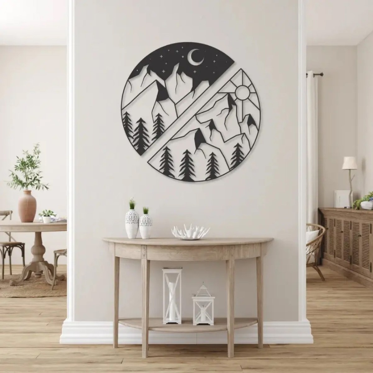 Sun and moon wall art: round black laser-cut metal design split into night and day over mountains, hung above a wooden console table