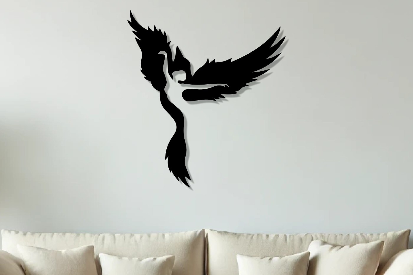 Phoenix wall art: black laser-cut Woman and Phoenix metal wall art silhouette hung above a cream sofa