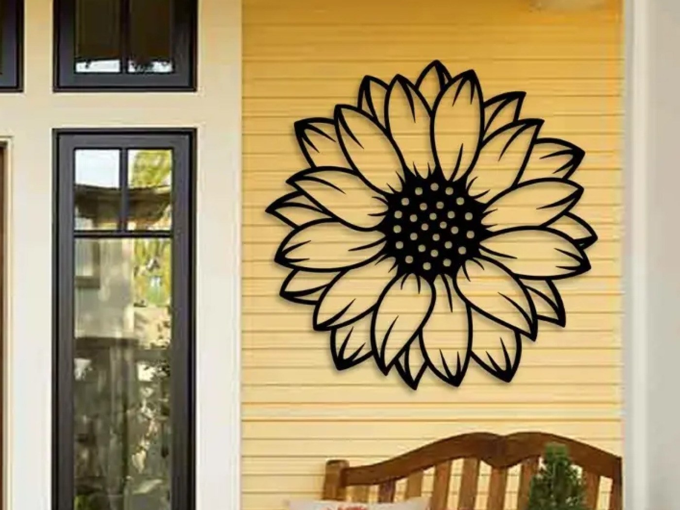 Black sunflower metal wall art on a warm yellow porch wall, an idea for nature wall art