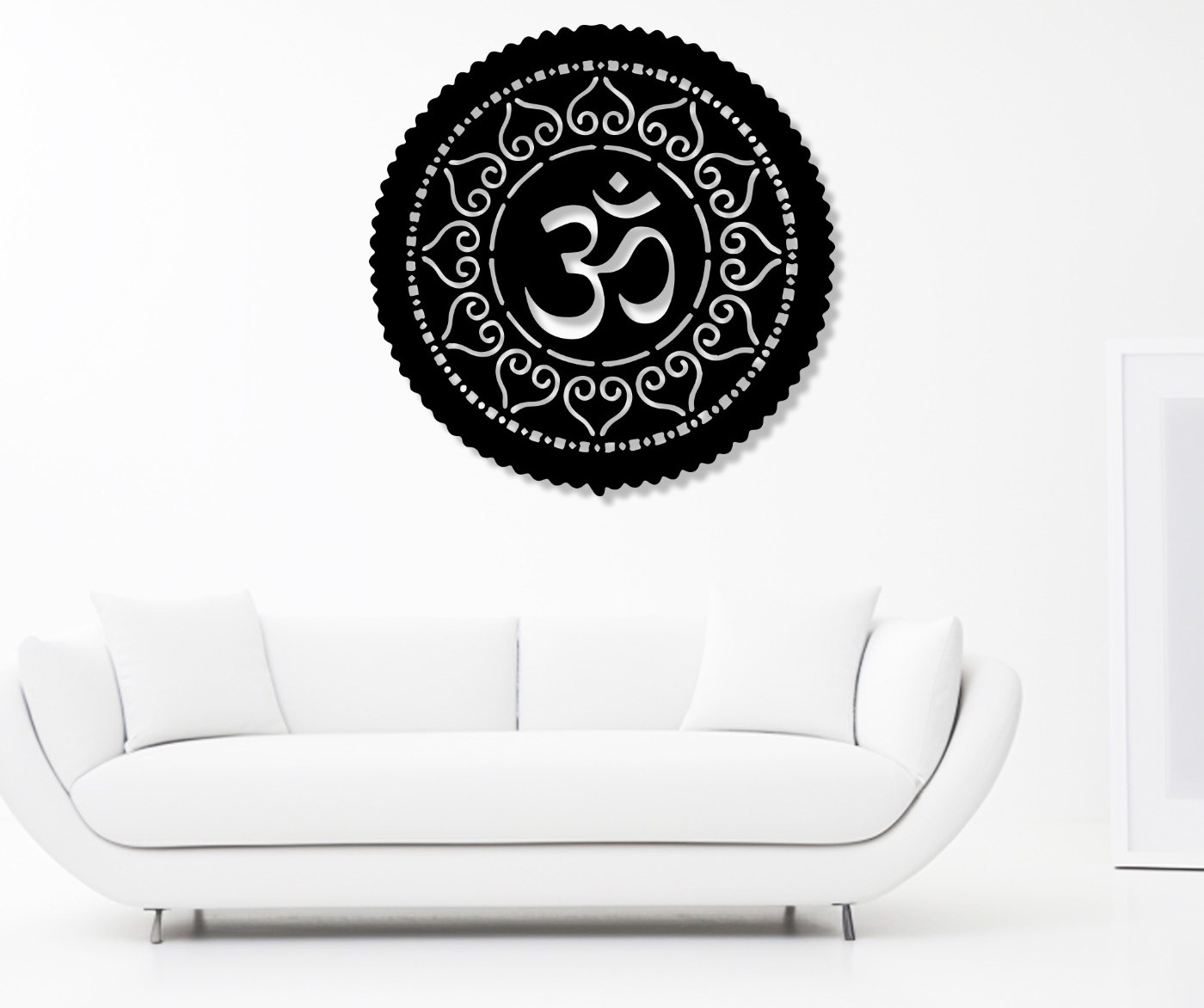 Black OM metal wall art in a round mandala design above a white sofa, a meditation wall art idea