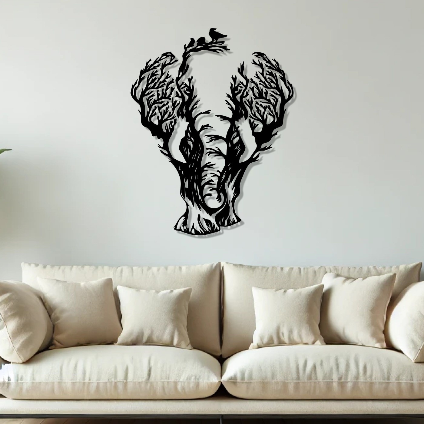 Elephant tree metal wall art above a beige sofa in a bright living room